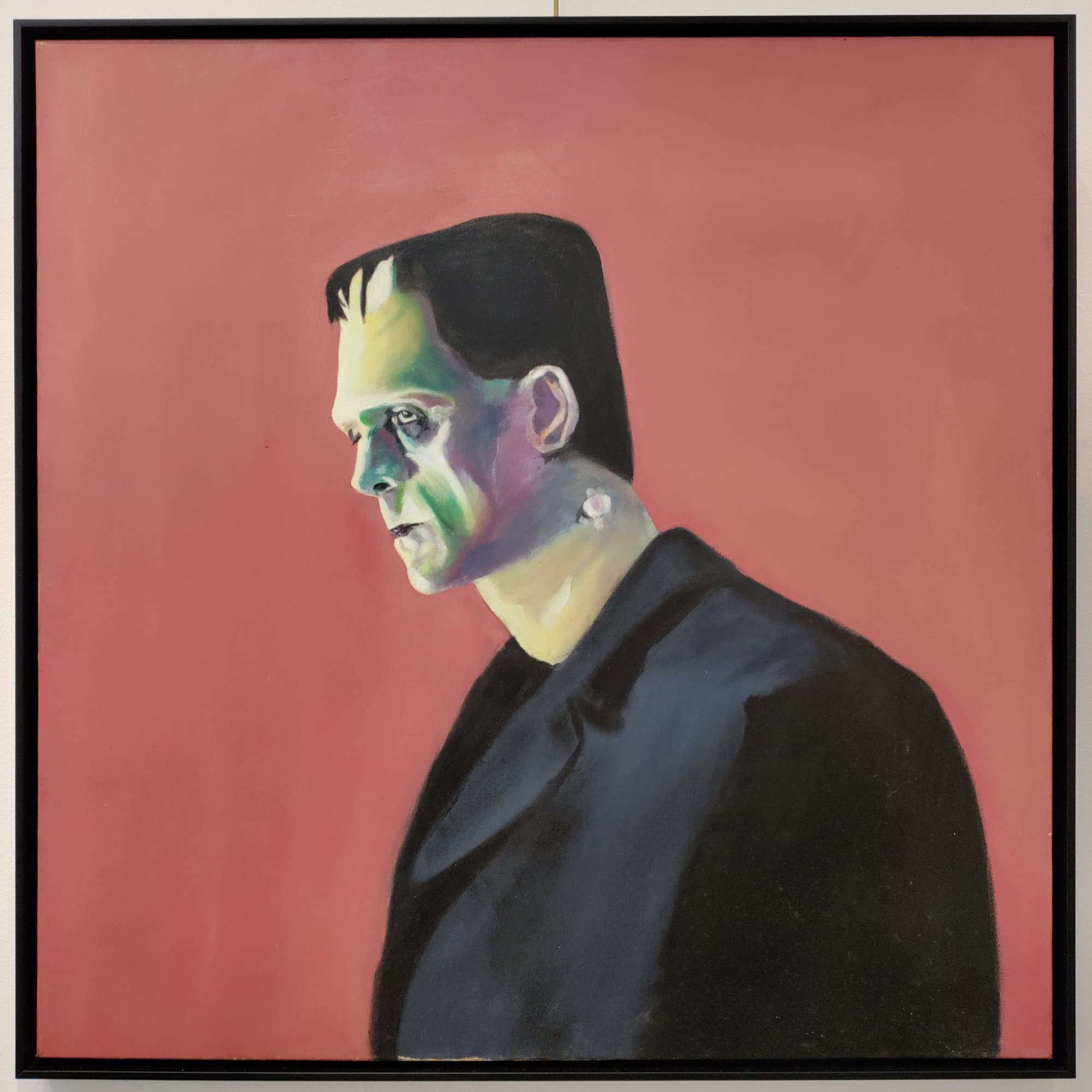 Painting of Frankenstein's monster against a coral background